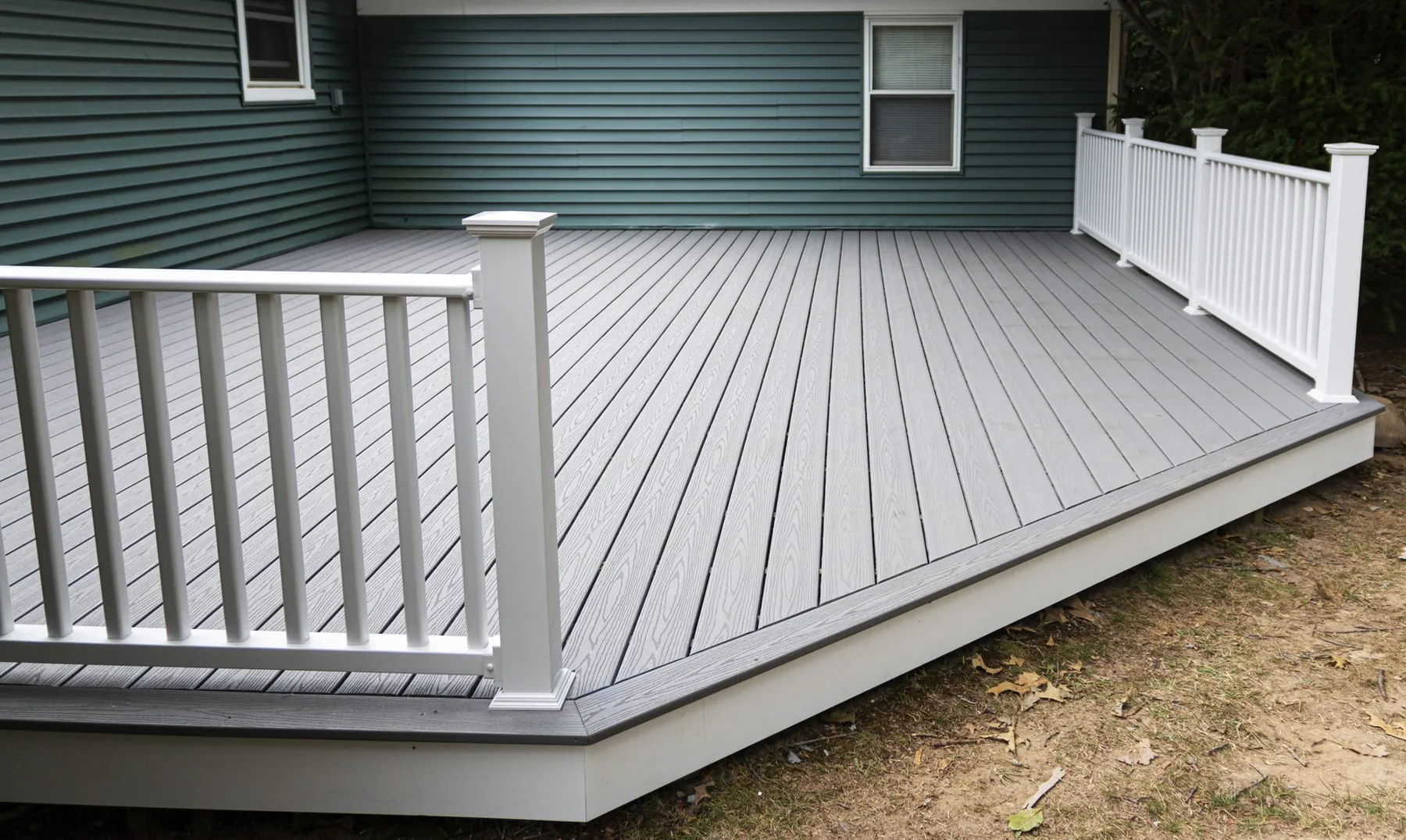 Gray composite deck boards paired with a crisp white railing