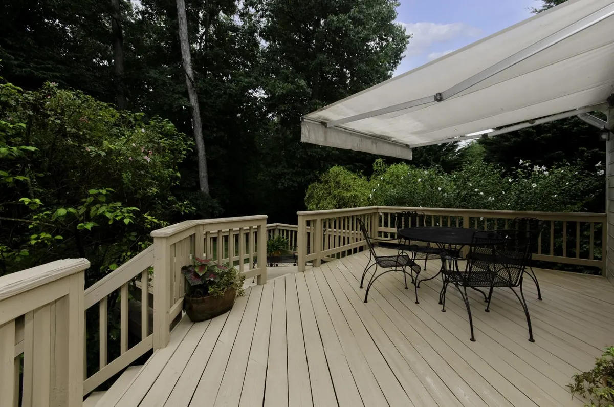 Wood deck with a retractable awning and an outdoor dining set