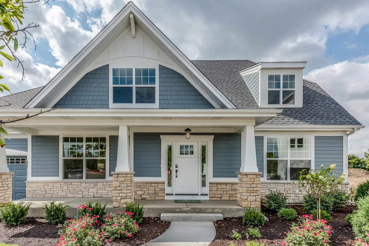 Blue craftsman home with white double-hung windows and shutters