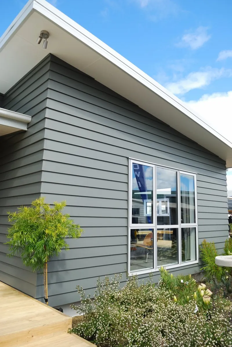Gray lap-siding modern home with a large white-framed picture window