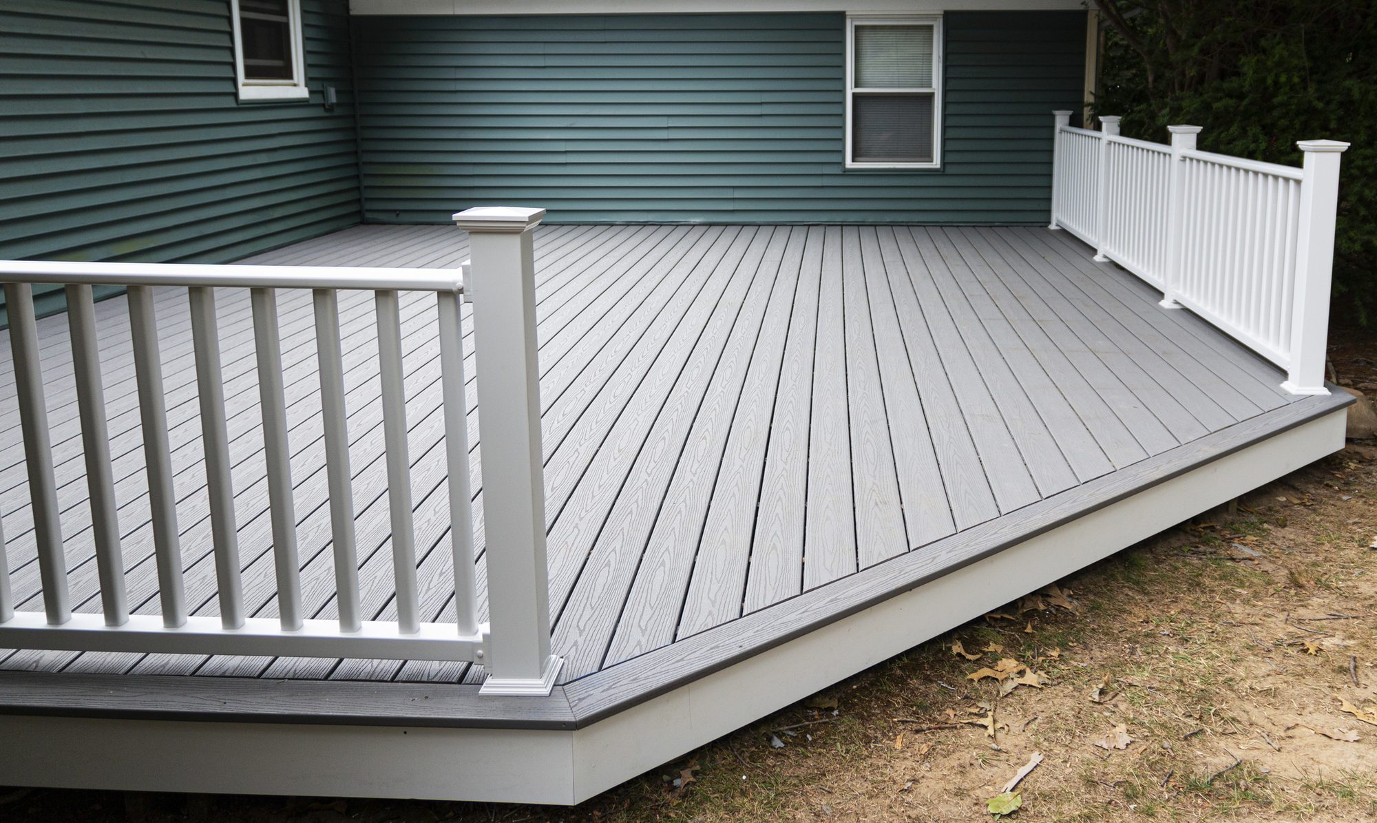 Gray composite deck boards paired with a crisp white railing