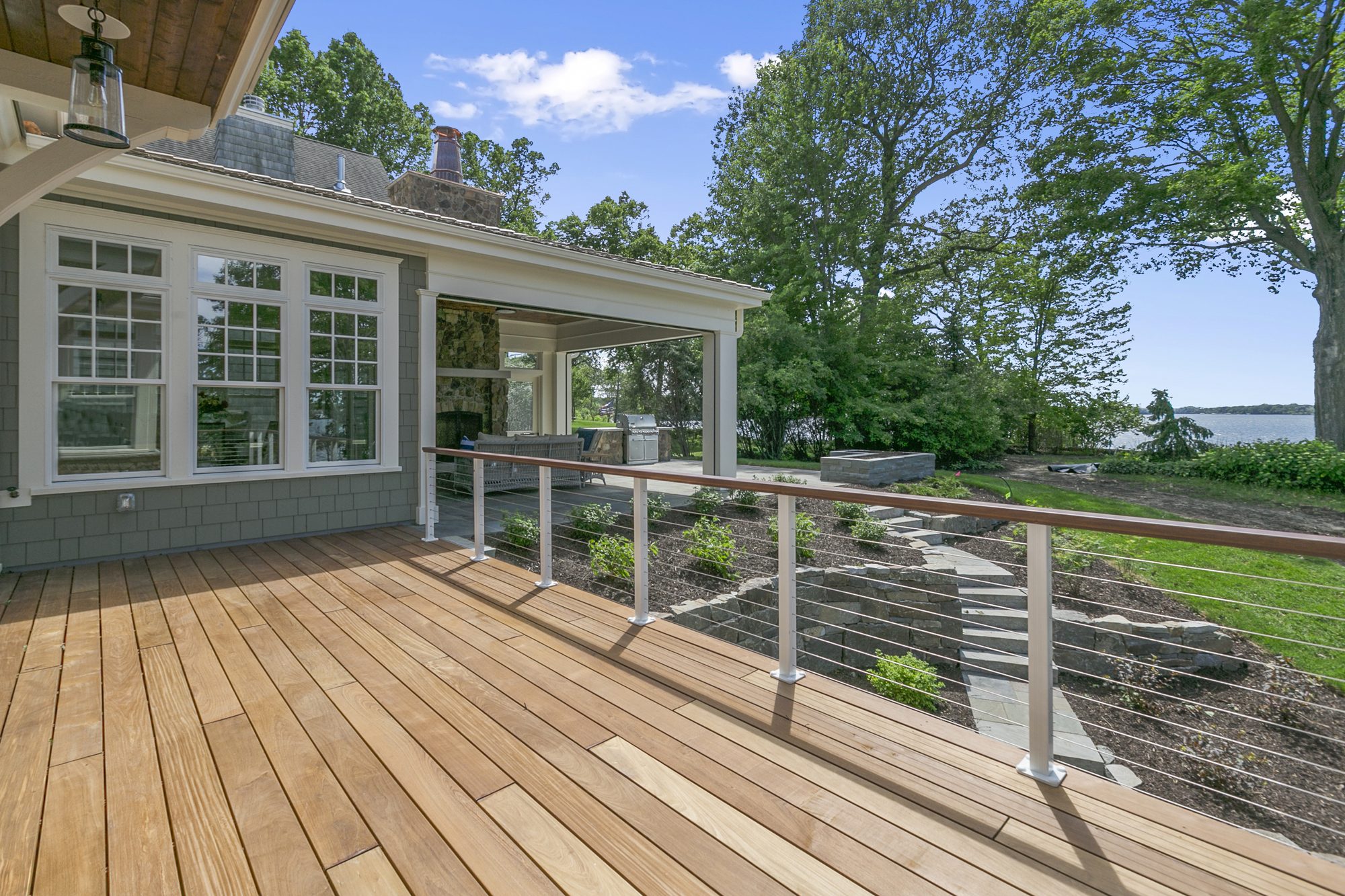 Hardwood deck with a stainless cable railing at a waterfront home