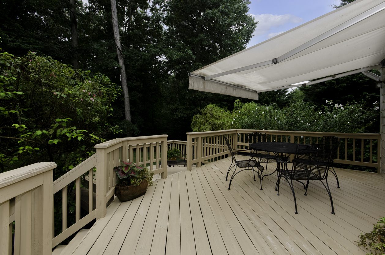 Wood deck with a retractable awning and an outdoor dining set