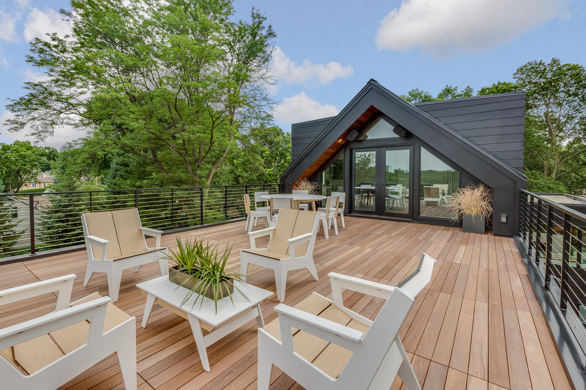 Rooftop deck with modern lounge furniture beside a contemporary home