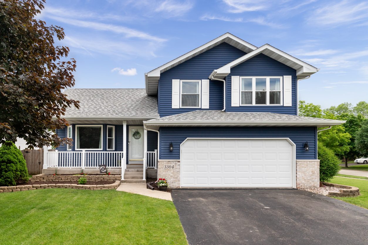 Two-story home with navy blue siding, white trim, and an attached garage