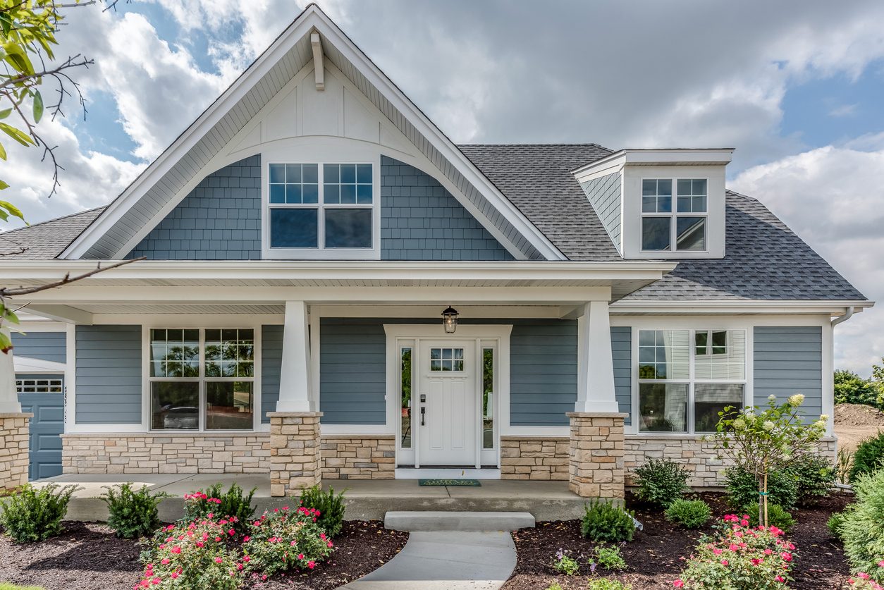 Blue craftsman home with white double-hung windows and shutters