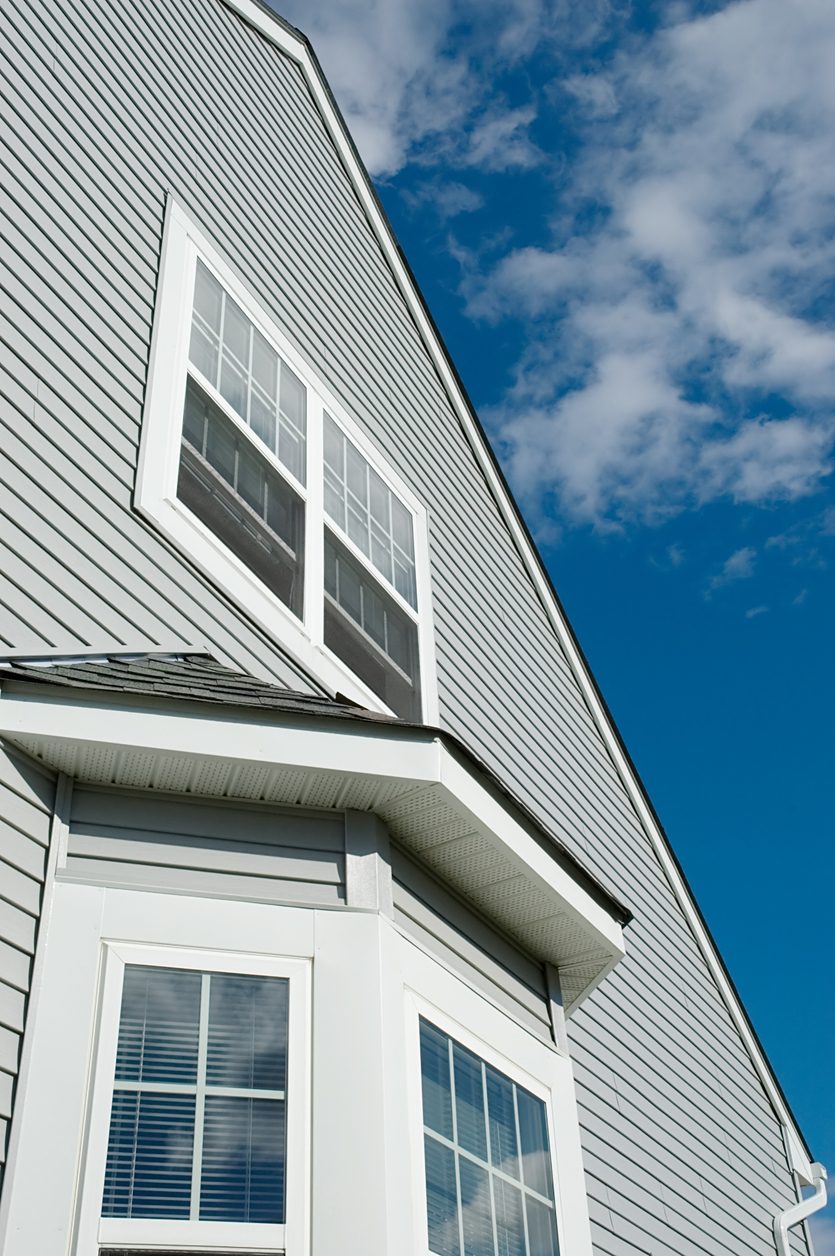 White bay window with double-hung sashes on a gray-sided home