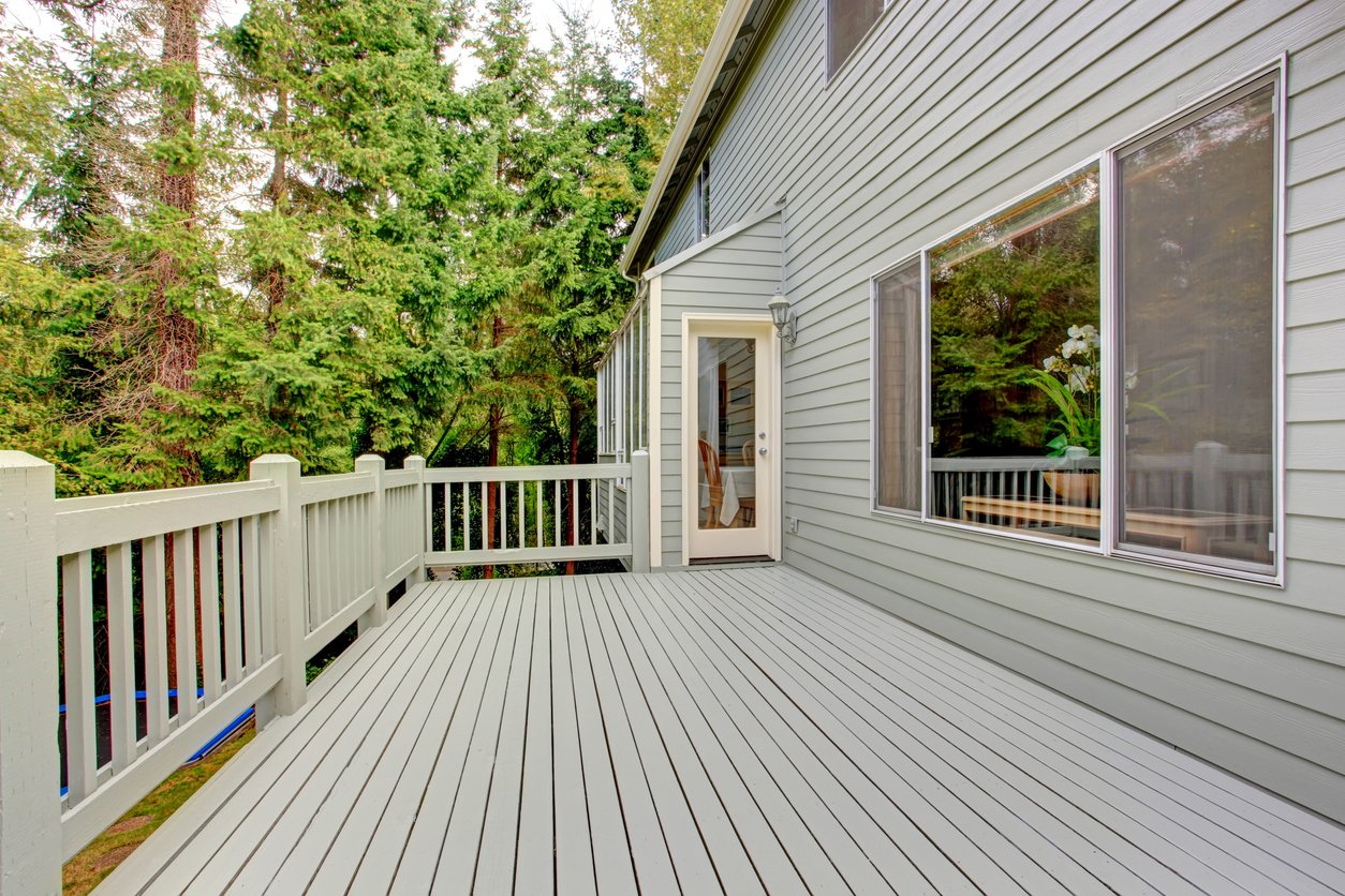 Gray-sided home with a backyard deck and large picture windows