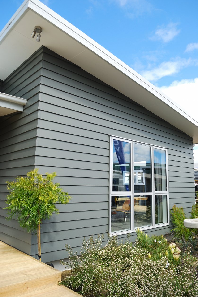 Gray lap-siding modern home with a large white-framed picture window