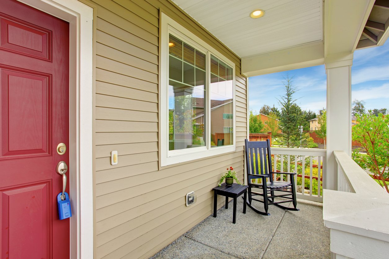 Tan-sided porch with a white grid-top slider window and a rocking chair